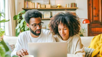 Een man en een vrouw kijken op de computer naar inboedelverzekeringen